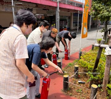 「火事だー」の掛け声のあと、火元を想定した植え込みまで歩み寄り、消火器を向けて放水体験を行いました。