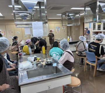 利用者のみなさんが、2階の準備室入ると早々に、身支度を整え、３班別れて、調理実習担当の職員さんから、調理のレシピ、調理手順などのレクチャーを受けて調理開始です。